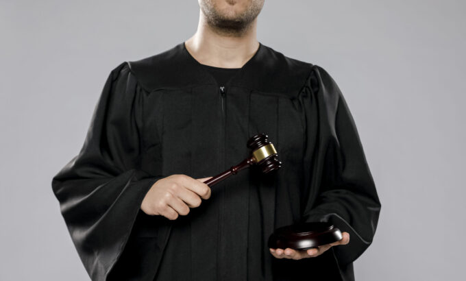 juiz-masculino-posando-com-martelo