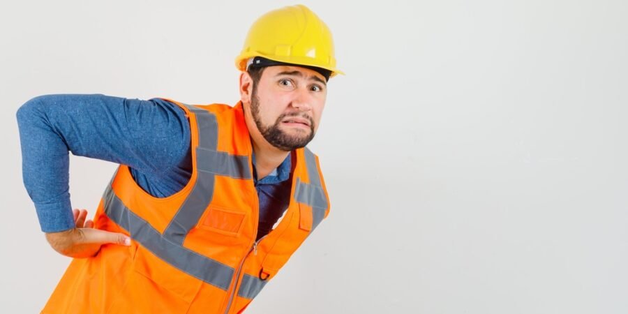 Trabalhador com dor nas costas representando situação relacionada à estabilidade por acidente de trabalho.
