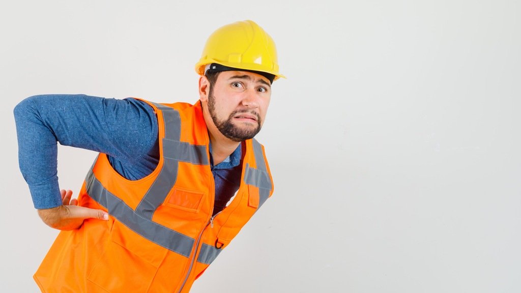 Trabalhador com dor nas costas representando situação relacionada à estabilidade por acidente de trabalho.