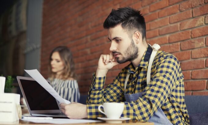 Homem analisa documento ao lado de um notebook, refletindo a dúvida: não trabalho de carteira assinada tenho algum direito.